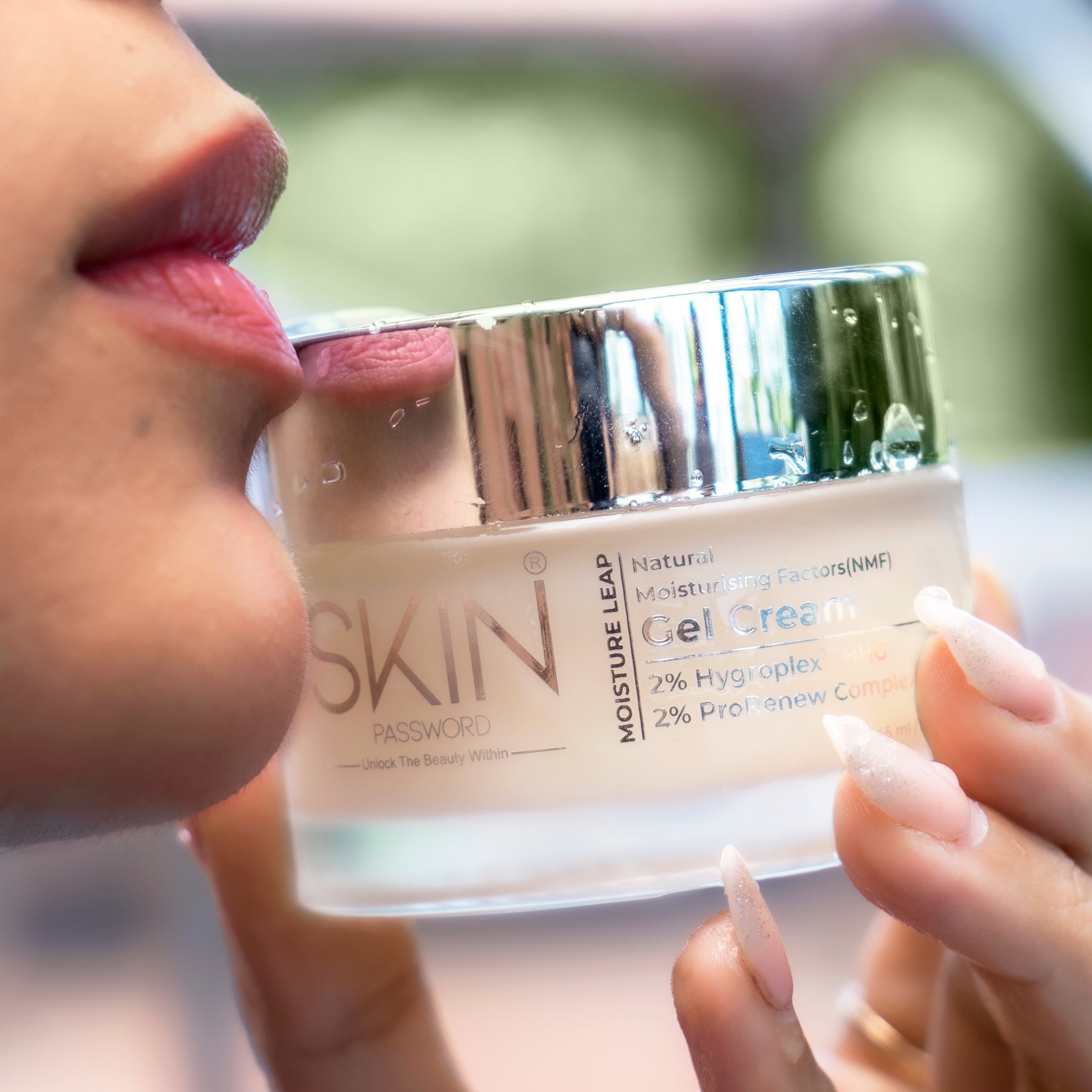 A woman holding a SkinPassword MoistureLeap Gel Cream near her lips.