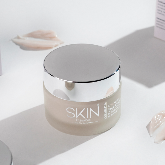 SkinPassword Postbiotic Anti-Aging Face Cream jar with a silver lid, surrounded by cream swatches.